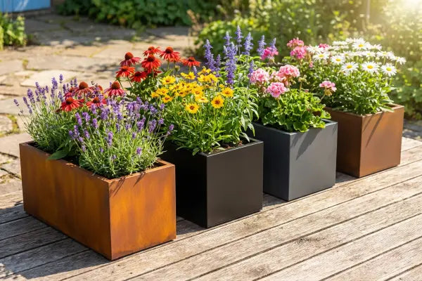 Different shade of trough planters in a row on some decking.